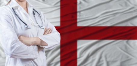 Doctor with crossed arms on England flag. England health and care concept. Female doctor on England