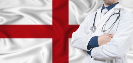 England healthcare concept. Male doctor on England flag. Doctor with crossed arms on England flag