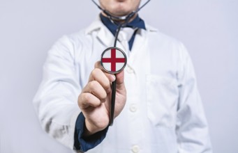 Doctor hands holding stethoscope with England flag. England health and care concept