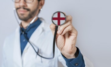 Doctor holding stethoscope with England flag. England health and care concept. England flag on