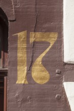 Golden house number plate number seventeen on a half-timbered house in the old town centre,