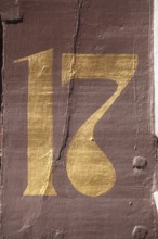 Golden house number plate number seventeen on a half-timbered house in the old town centre,