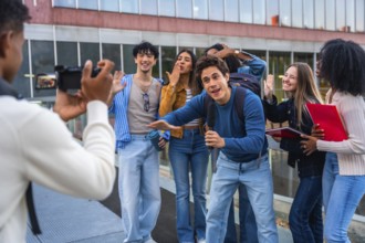 Group of happy diverse university students recording a video blog together with a camera, capturing
