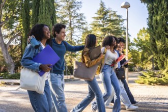 Group of happy university students from different ethnicities walking together on a university