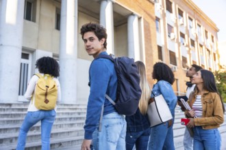 Group of young adult students walking on a university campus building staircase, representing