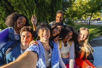 Group of happy multicultural young adult friends smiling and posing for a selfie while standing