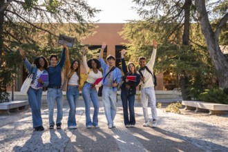 Group of diverse young university students happily standing in front of a campus building, smiling