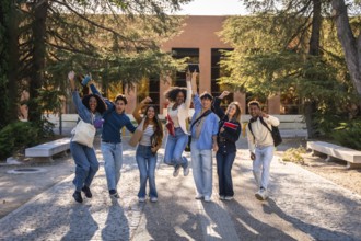 Group of excited multi ethnic students celebrating success and friendship, walking and jumping on a