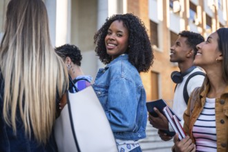 Group of multi ethnic university students walking together on campus, smiling, and looking around,
