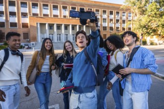 Diverse students standing together on a university campus, smiling and vlogging, capturing joyful