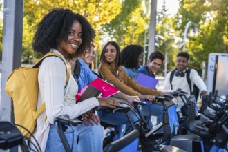 Group of happy multiracial university students smiling and preparing to use shared bicycles from a