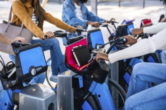 Diverse university students sharing blue urban bikes, enjoying eco friendly campus commutes and