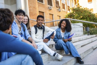 Diverse group of multiracial youth sitting on campus steps, engaging in conversation and smiling