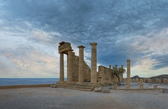 Ancient ruins of the Temple of Athena on the Acropolis of Lindos with columns in front of a calm