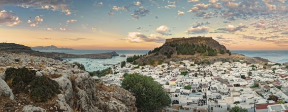 Panoramic view of the Greek town of Lindos by the sea with Acropolis at sunset with dramatic sky