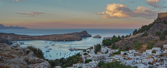 Harbour and coast of Lindos with boats at sunset, Acropolis, Lindos, Rhodes, Island, Greece
