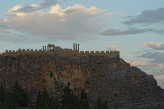The ancient Acropolis of Lindos on jagged rocks against a dramatic sky at dusk, Acropolis, Lindos,