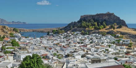 The picturesque town of Lindos with acropolis with white buildings near the coast, overlooked from
