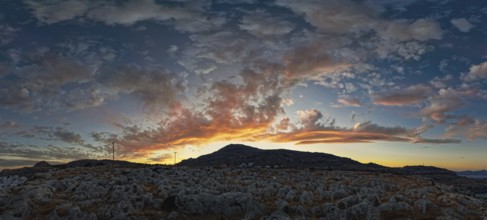 Dramatic landscape of Lindos with a mountain in the background and colourful sunset in the sky,