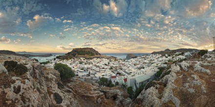 Panoramic view of the Greek town of Lindos by the sea with Acropolis at sunset with dramatic sky