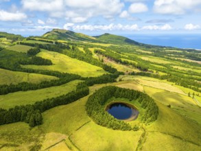 Lake Pau Pique and Lush Green Hills with Pastureland and Trees. Shadows of Clouds. Atlantic Ocean.