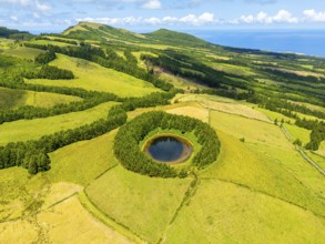 Lake Pau Pique and Lush Green Hills with Pastureland and Trees. Atlantic Ocean. Azores, Sao Miguel