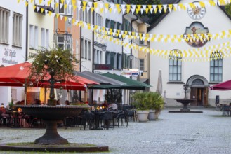 Fountain, outdoor seating at a restaurant, parasols, St John's Church, market square, Feldkirch,