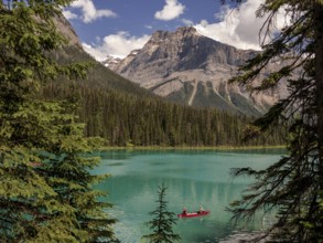 Canoe with explorers on Emerald Lake surrounded by the Canadian Rocky Mountains within Yoho