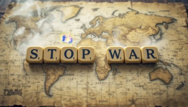 The image features the words 'STOP WAR' spelled out on letter tiles, placed over a vintage world