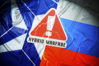 The flags of NATO and Russia with danger sign and inscription Hybrid Warfare, symbolic photo of