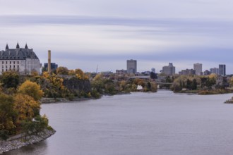 A city skyline seen across a the Ottawa River during an overcast autumn day in Ottawa, Ontario,