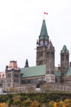 The Canadian parliament building with a prominent clock tower and Canadian flag in Ottawa, Ontario,