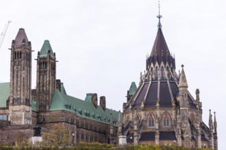 The Canadian Parliament Building with gothic architecture and towers against a cloudy sky in