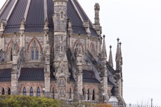 A detailed view of a gothic-style stone building of the Canadian Parliament Buildings with