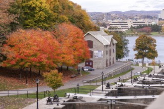 A stone house surrounded by vibrant autumn trees near a river, within a park setting, exuding