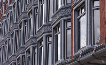 Close-up of a building facade with multiple windows and ornate architectural details, featuring a