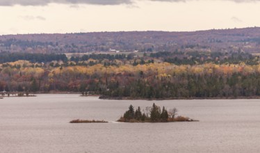 The Ottawa River with small islets surrounded by colorful autumn trees and hills in Ottawa,