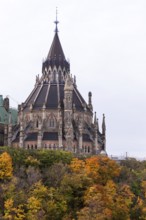 The Canadian Parliament Buildings with spires surrounded by colorful autumn trees in Ottawa,