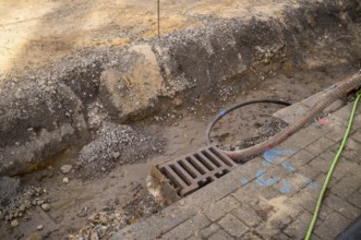 Borken, NRW, Germany, Trench excavation showing earth, mud, gravel, a storm drain, and pipes during