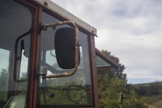 Borken, NRW, Germany, Rusty cabin and side mirror of an old agricultural tractor showing rural