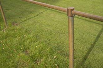 Borken, NRW, Germany, Bronze colored metal railing creating a barrier in a park with lush green
