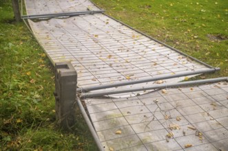 Borken, NRW, Germany, Temporary metal fence panels lying on the ground surrounded by green grass