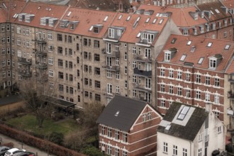 Dense urban scene with red tile roofed residential buildings under an overcast sky in Aarhus,