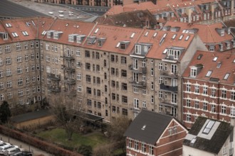 View of apartment buildings with red tile rooftops under a cloudy sky in Aarhus, Denmark, Northern