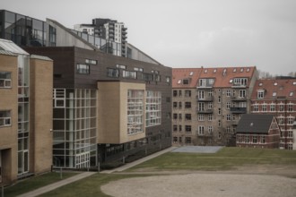 Contrasting modern and traditional buildings in an urban setting with a gray sky in Aarhus,