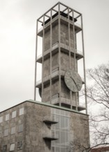 Tall concrete clock tower with minimalistic design against a cloudy sky in Aarhus, Denmark,