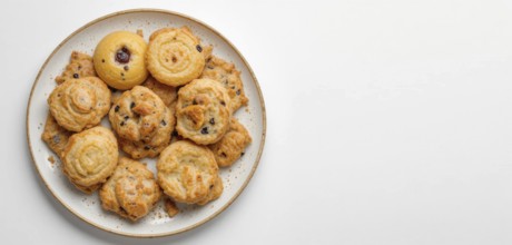 A top-down shot showcases a variety of golden-brown cookies arranged on a speckled plate against a