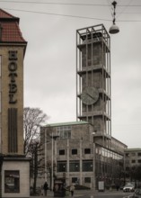 A modern concrete building with a large clock under a gray sky in Aarhus, Denmark, Northern Europe