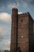 The Karnan medieval tower, built in the early 14th century, with a flag set against a blue sky with