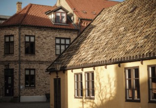 Buildings with contrasting rooftops and sunlight casting shadows, an urban architectural scene in